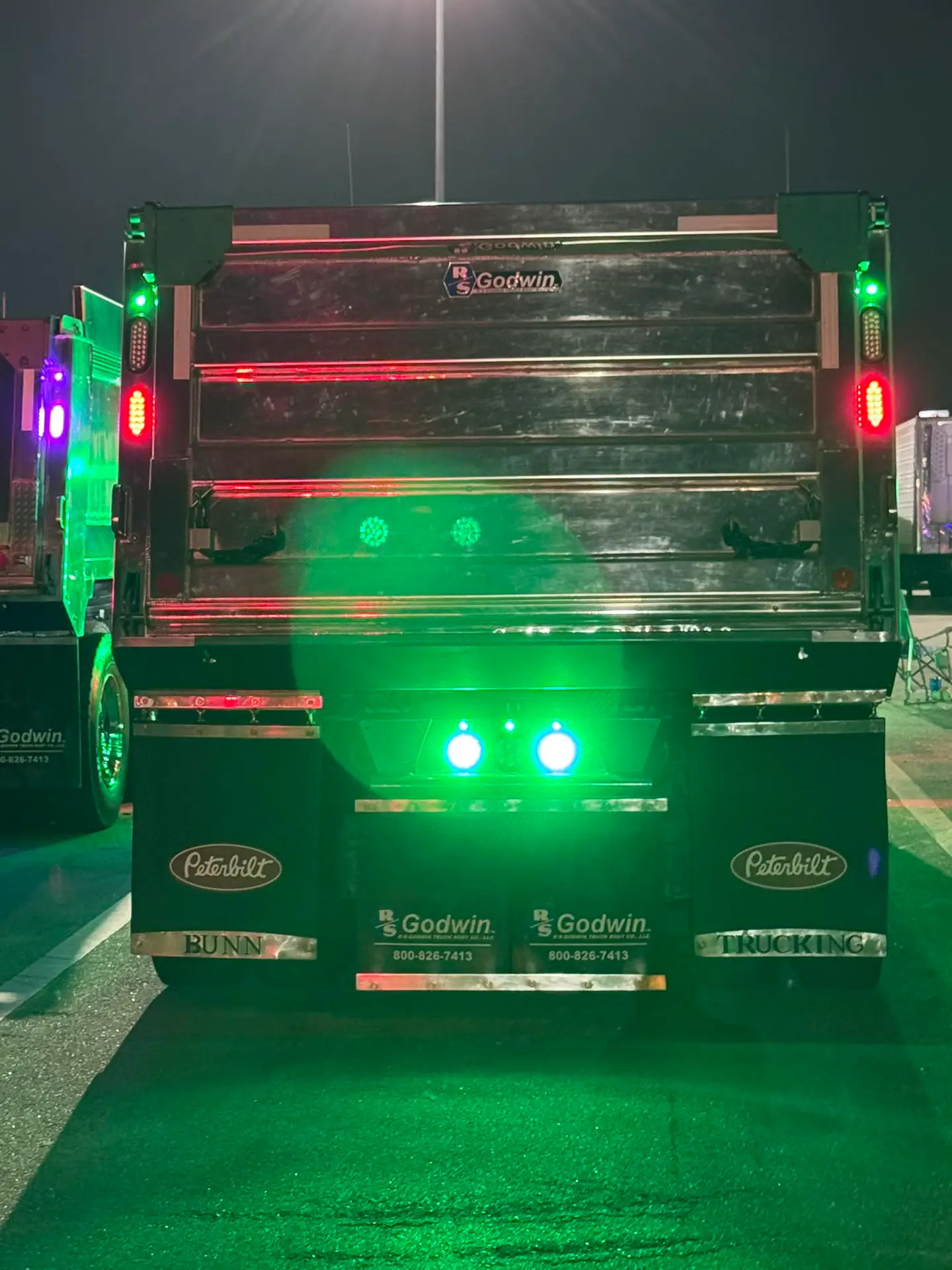 Rear of a Bunn Trucking Peterbilt dump truck glowing with green lights