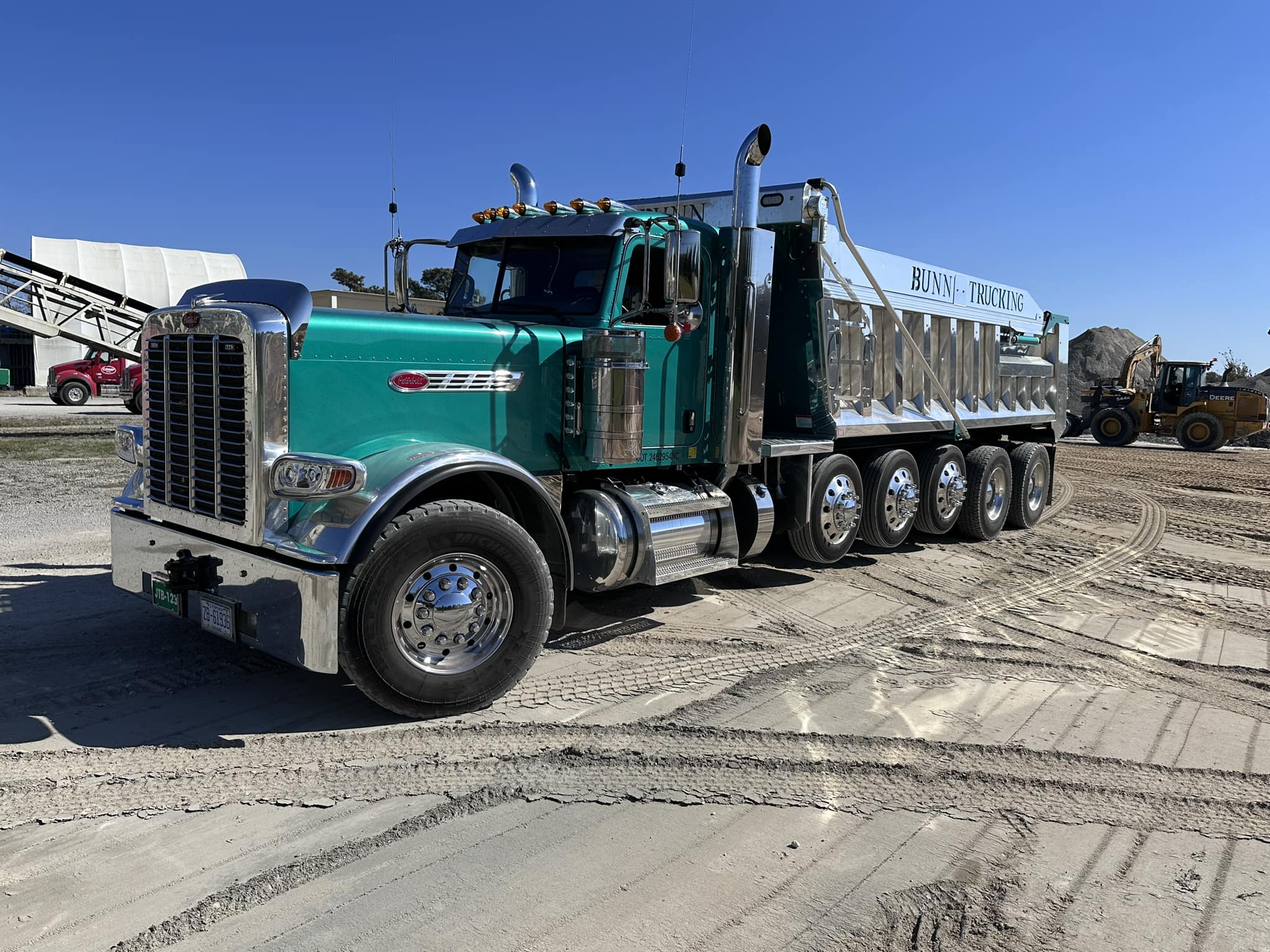 Green dump truck on a dirt job site