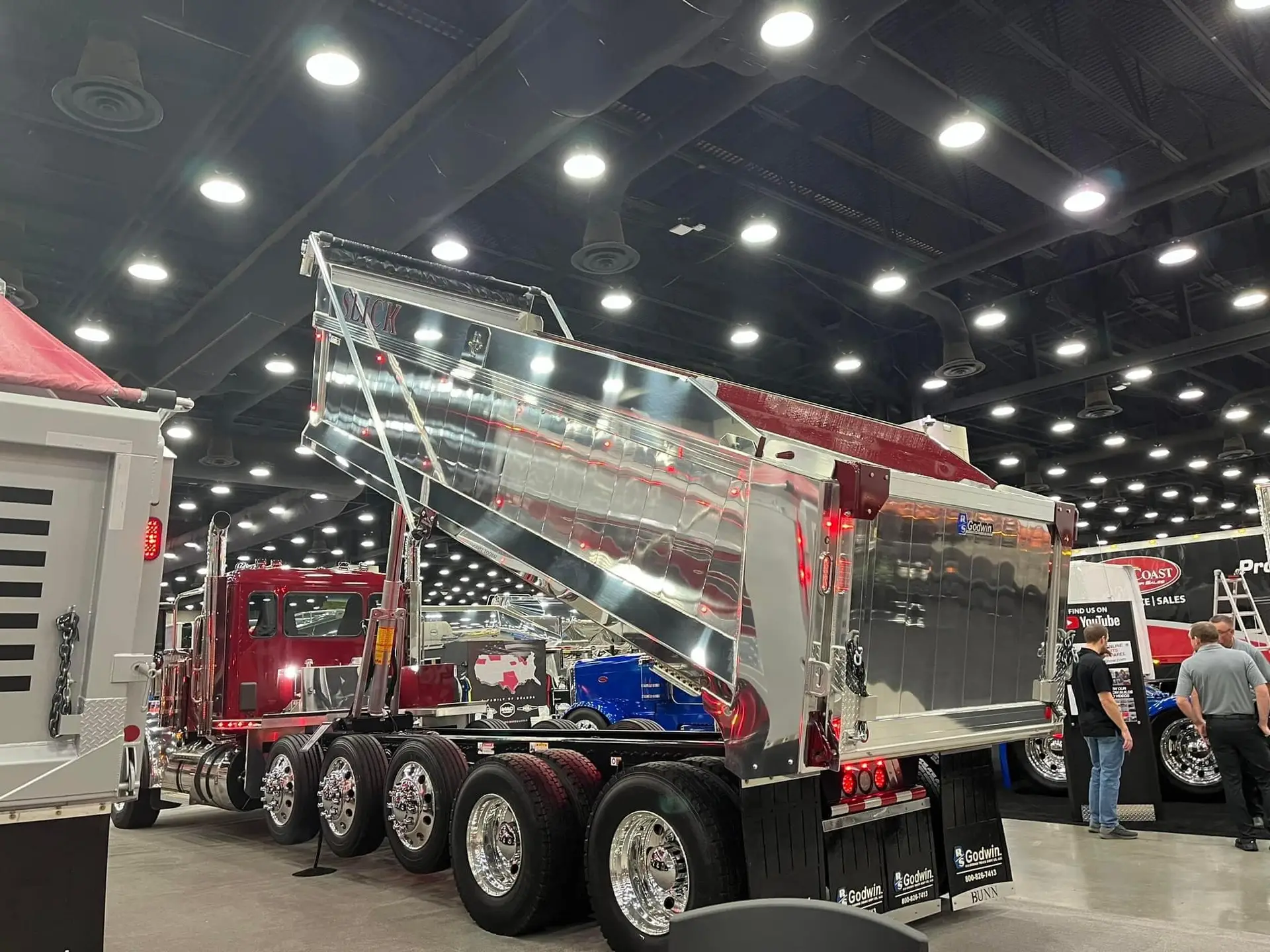 Polished chrome Bunn family dump trailer on display at an indoor truck show